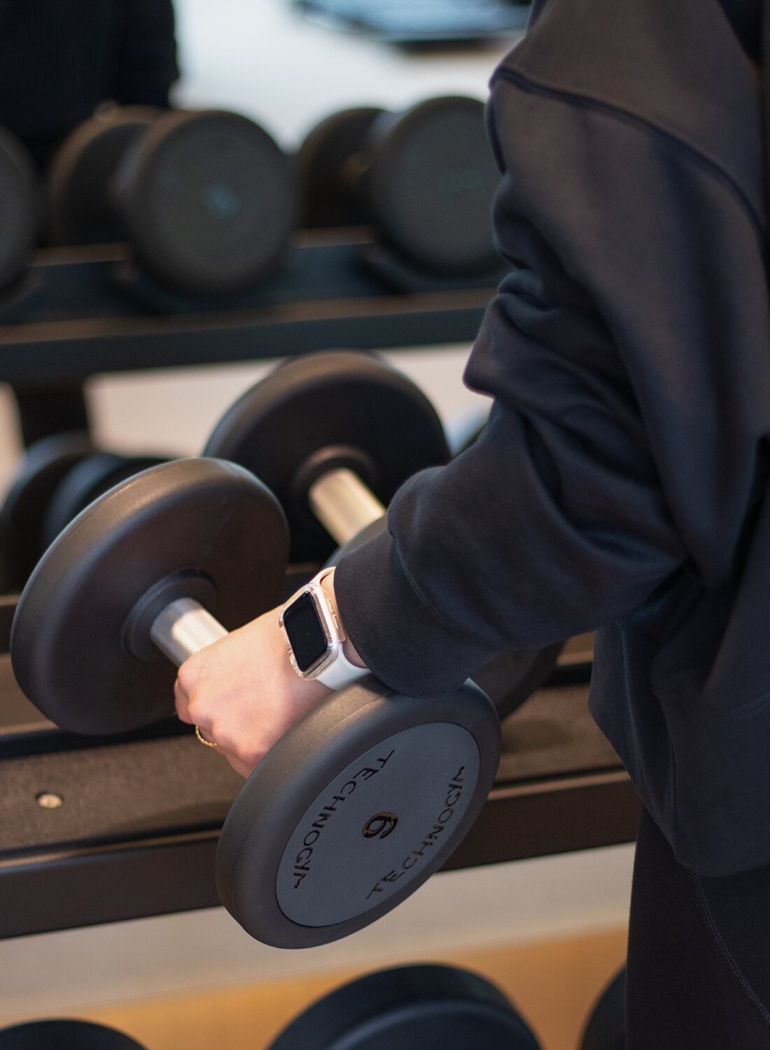 A member taking a dumbbell from the rack